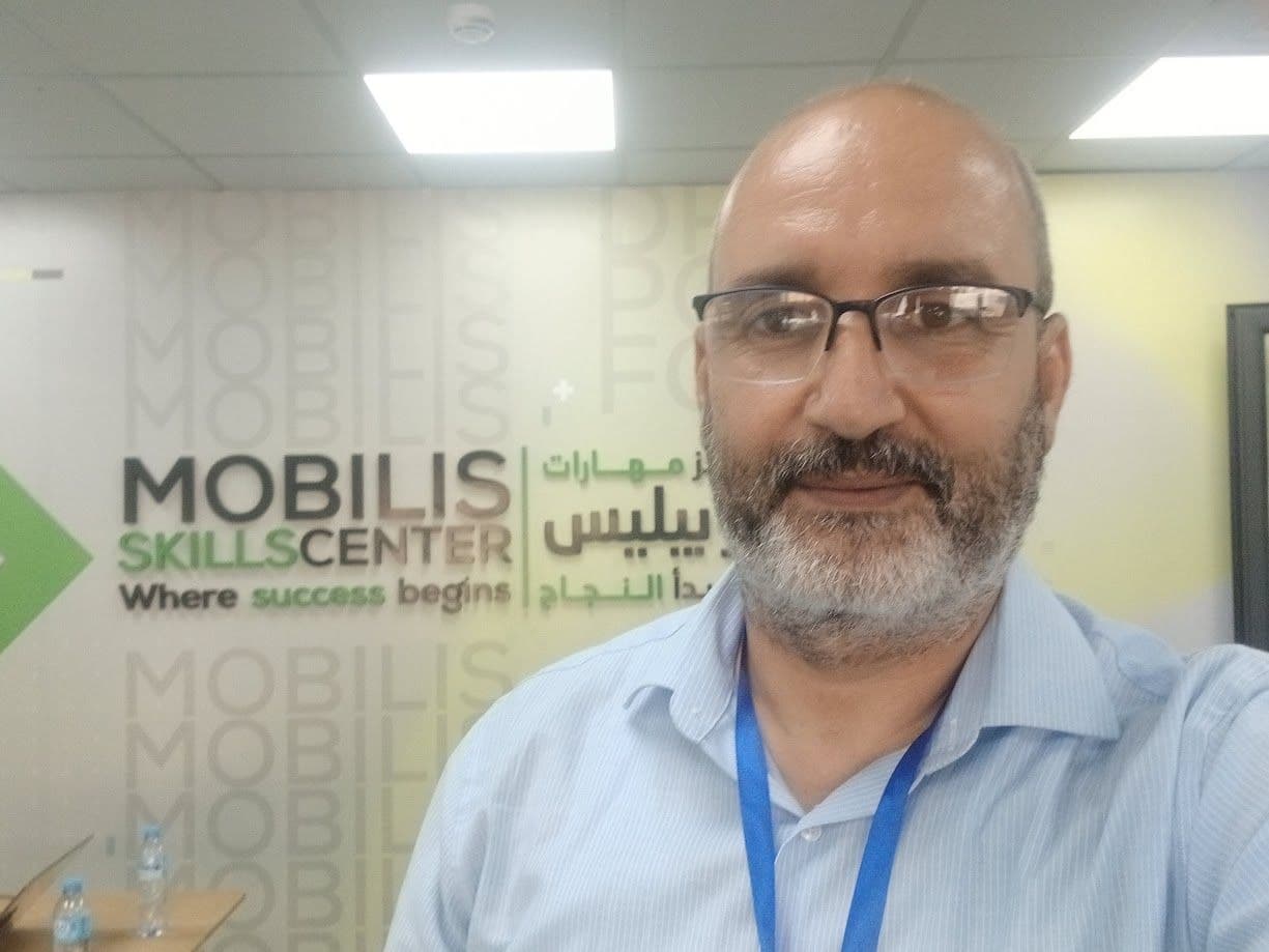 Selfie in front of the Mobilis Skills Center wall at 7.77, 2026.